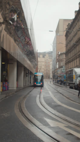 Vertical-Video-Of-Tram-In-Front-Of-The-Grand-Central-Shopping-Centre-In-Birmingham-UK-On-Rainy-Day